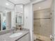 Bathroom featuring granite countertops, a mirrored medicine cabinet and a glass-enclosed shower at 1159 Lake House Cir # C120, Sarasota, FL 34242