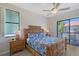Cozy bedroom featuring a decorative woven headboard, a ceiling fan, and access to a private balcony at 1159 Lake House Cir # C120, Sarasota, FL 34242