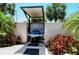 Covered community grill with granite top surrounded by lush tropical plants and landscaping at 1159 Lake House Cir # C120, Sarasota, FL 34242