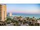 Beautiful sunset view over the beachfront condo and palm-lined entrance at 1212 Benjamin Franklin Dr # 909, Sarasota, FL 34236