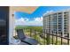 Enjoy this balcony view with seating overlooking lush greenery and distant water at 1212 Benjamin Franklin Dr # 909, Sarasota, FL 34236