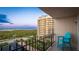 Balcony with a bright blue Adirondack chair offering sunset views of the bay at 1212 Benjamin Franklin Dr # 909, Sarasota, FL 34236
