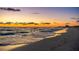 Picturesque beach view with golden sand and calming waves under a colorful sky at 1212 Benjamin Franklin Dr # 909, Sarasota, FL 34236