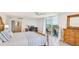 Spacious bedroom featuring a private balcony with ocean views, a work desk, and a serene atmosphere at 1212 Benjamin Franklin Dr # 909, Sarasota, FL 34236
