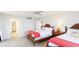 Bright bedroom featuring two twin beds, tile floors, and a glimpse into the ensuite bathroom at 1212 Benjamin Franklin Dr # 909, Sarasota, FL 34236