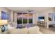 Inviting living room features coastal decor, access to a balcony with water views, and a TV viewing area at 1212 Benjamin Franklin Dr # 909, Sarasota, FL 34236