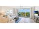 Charming living room with tiled floors, balcony access with picturesque water views, and comfortable coastal furnishings at 1212 Benjamin Franklin Dr # 909, Sarasota, FL 34236