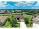 Aerial view of a single Gathering home featuring a well-manicured lawn, mature landscaping, and a serene pond at 12815 24Th Street E Cir, Parrish, FL 34219