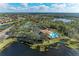 Aerial view featuring community pool, tennis courts, landscaping and lakeside at 12815 24Th Street E Cir, Parrish, FL 34219