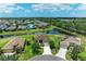 Aerial shot of a landscaped home with a spacious yard, serene pond views, and lush surroundings at 12815 24Th Street E Cir, Parrish, FL 34219