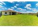 Expansive backyard with lush green grass, a black fence, and a view of neighboring houses at 12815 24Th Street E Cir, Parrish, FL 34219