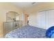 Bright bedroom featuring a decorative dresser and a large closet with a blue patterned bedspread at 12815 24Th Street E Cir, Parrish, FL 34219