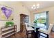 Dining area featuring modern chandelier, glass top table, view of the backyard through sliding glass door at 12815 24Th Street E Cir, Parrish, FL 34219