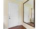 Bright entryway featuring hardwood floors, a large mirror, and a white door, creating a welcoming entrance at 12815 24Th Street E Cir, Parrish, FL 34219