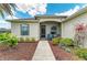 Cozy home exterior features a screened front porch, a well-kept walkway, and vibrant flowerbeds at 12815 24Th Street E Cir, Parrish, FL 34219