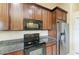 Updated kitchen features stainless steel appliances and granite countertops paired with wood cabinets at 12815 24Th Street E Cir, Parrish, FL 34219