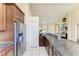 Bright kitchen features stainless steel refrigerator, tile flooring, and granite countertops at 12815 24Th Street E Cir, Parrish, FL 34219