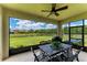 Screened patio with ceiling fan, outdoor dining table set overlooking a beautifully landscaped backyard at 12815 24Th Street E Cir, Parrish, FL 34219
