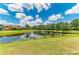 Scenic view of a pond reflecting the sky and surrounding trees in a residential community at 12815 24Th Street E Cir, Parrish, FL 34219