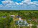 Aerial view of a modern home with lush landscaping, highlighted by a red outline, showcasing its serene setting at 1375 Norwalk Ter, Port Charlotte, FL 33953