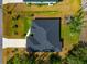 An overhead view of a well-maintained home with a dark roof, neat lawn, and an adjacent playground area at 1375 Norwalk Ter, Port Charlotte, FL 33953