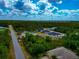 Overhead view of multiple homes nestled among lush greenery with a bright, partly cloudy sky above at 1375 Norwalk Ter, Port Charlotte, FL 33953