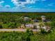 Expansive aerial view of the home nestled among lush greenery under a bright blue sky with scattered clouds at 1375 Norwalk Ter, Port Charlotte, FL 33953
