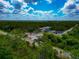 Aerial view of houses surrounded by lush greenery, RV parking, and blue sky with scattered clouds at 1375 Norwalk Ter, Port Charlotte, FL 33953