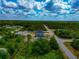 Aerial perspective featuring several homes along a road, surrounded by lush trees under a bright, cloudy sky at 1375 Norwalk Ter, Port Charlotte, FL 33953