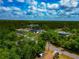 Aerial image showcasing residences surrounded by lush greenery and trees beneath a bright, partly cloudy sky at 1375 Norwalk Ter, Port Charlotte, FL 33953