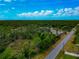 Expansive aerial view of a home nestled within a lush, green landscape under a bright, partly cloudy sky at 1375 Norwalk Ter, Port Charlotte, FL 33953
