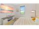 Bright bedroom boasts a beachy sunset artwork, large window, and a stylish media console at 1375 Norwalk Ter, Port Charlotte, FL 33953