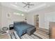 Bright bedroom featuring a tray ceiling, accent rug, and ensuite bathroom at 1375 Norwalk Ter, Port Charlotte, FL 33953
