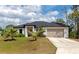 Charming home featuring a well-manicured lawn, a two-car garage, and a welcoming entrance, perfect for families at 1375 Norwalk Ter, Port Charlotte, FL 33953