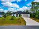Beautiful single-story home with a concrete driveway and vibrant green lawn with palm trees at 1375 Norwalk Ter, Port Charlotte, FL 33953