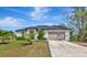 Beautiful home showcasing a two-car garage, complemented by lush landscaping and a well-maintained lawn at 1375 Norwalk Ter, Port Charlotte, FL 33953