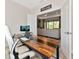 Inviting home office with wood desk, modern chair, and view into the light and bright living space at 1375 Norwalk Ter, Port Charlotte, FL 33953