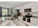 Bright kitchen features stainless steel appliances, white cabinets and a large granite kitchen island perfect for entertaining at 1375 Norwalk Ter, Port Charlotte, FL 33953