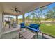 Relaxing screened patio with stylish seating, ceiling fan, and an outdoor kitchen area overlooking a spacious yard at 1375 Norwalk Ter, Port Charlotte, FL 33953