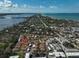 An aerial shot shows a dense residential area with red-tiled roofs nestled between waterways and beaches at 151 Vista Hermosa Cir # 31C, Sarasota, FL 34242