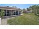 A well-maintained backyard shows a screened-in patio and a lush lawn leading to neighboring houses at 151 Vista Hermosa Cir # 31C, Sarasota, FL 34242