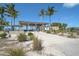 A beach access point featuring a covered shelter, walkways, and lush vegetation on a sunny day at 151 Vista Hermosa Cir # 31C, Sarasota, FL 34242
