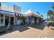 Several beach-themed shops with awnings and displays, located along a brick-paved street near the coast at 151 Vista Hermosa Cir # 31C, Sarasota, FL 34242