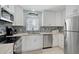 Well-appointed kitchen featuring white cabinetry, stainless steel appliances, and modern design for seamless cooking at 151 Vista Hermosa Cir # 31C, Sarasota, FL 34242