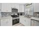 Bright kitchen with white cabinets, stainless steel appliances, and a unique backsplash that enhances the cooking space at 151 Vista Hermosa Cir # 31C, Sarasota, FL 34242