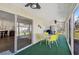 A screened-in patio features a ceiling fan and yellow table set, perfect for outdoor dining and relaxation at 151 Vista Hermosa Cir # 31C, Sarasota, FL 34242