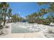 A playground with swings and a climbing area surrounded by palm trees and greenery under a blue sky at 151 Vista Hermosa Cir # 31C, Sarasota, FL 34242
