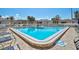 Triangular-shaped community pool with lounge chairs and palm trees in the background at 151 Vista Hermosa Cir # 31C, Sarasota, FL 34242