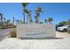 A Siesta Beach sign at a Sarasota County Park surrounded by lush palm trees and blue skies at 151 Vista Hermosa Cir # 31C, Sarasota, FL 34242