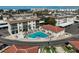 Aerial shot of a community pool area featuring a gated fence, sun loungers, and nearby cabana at 151 Vista Hermosa Cir # 31C, Sarasota, FL 34242